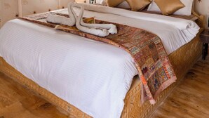 Une chambre à coucher avec un grand lit, une table de chevet et une fenêtre.