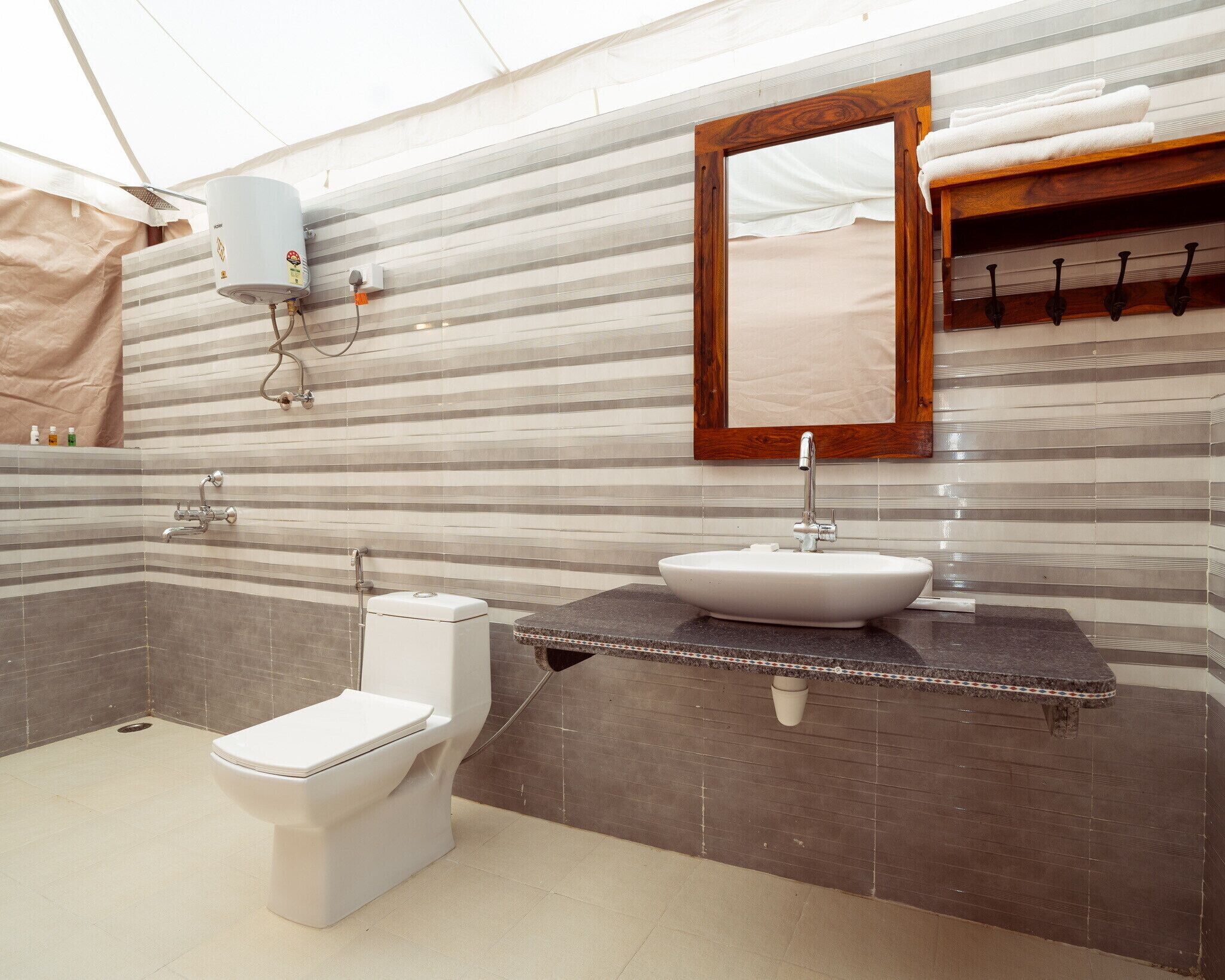 Une salle de bain avec des toilettes blanches, un lavabo et une douche.
