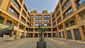 Un hôtel moderne doté d’une cour intérieure, de nombreux balcons et offrant une vue sur un ciel dégagé.