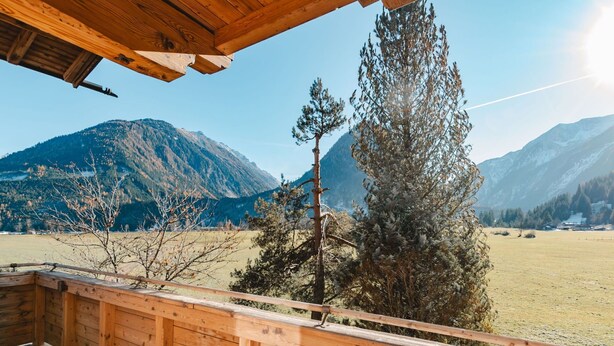 Una terraza de madera con vistas a un paisaje montañoso.