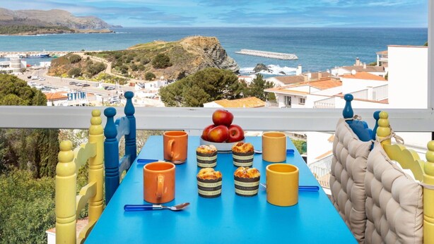 A table with food and drinks on a balcony overlooking a coastal view. - Lovely apartment for 4 guests with TV and terrace (Llançà)