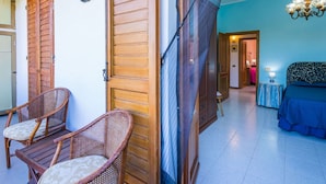 A room with a bed, a chair, a wooden door, and a ceiling fan. - Beautiful private villa for 4 guests with WIFI, patio and pets allowed (Bucine)