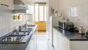 A modern kitchen with a gas stove, microwave, and a coffee machine. - Beautiful apartment for 5 guests with A/C, WIFI, TV and balcony (Rome)
