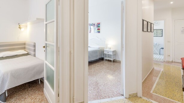A bedroom with a bed, bedside table, and a wall-mounted air conditioner. - Beautiful apartment for 5 guests with A/C, WIFI, TV and balcony (Rome)