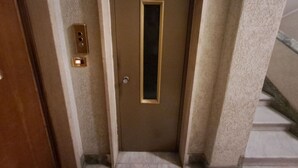 A narrow hallway with a door at the end, a light switch, and a small window. - Beautiful apartment for 5 guests with A/C, WIFI, TV and balcony (Rome)