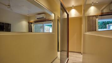 Habitación de hotel moderna con separador de vidrio, ventilador de techo, aire acondicionado y vistas al exterior.