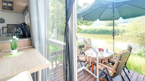 A cozy room with a wooden table, a potted plant, and a view of a deck with outdoor furniture. - Nice apartment in villa for 4 guests with WIFI, TV and terrace (Beilngries)
