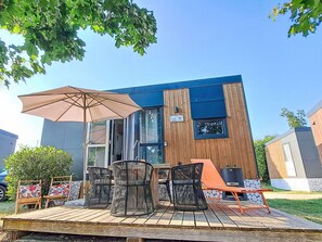 A modern outdoor seating area with a table, chairs, and a large umbrella.