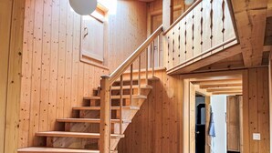 Un escalier en bois, doté d’une rampe, mène à un niveau supérieur.