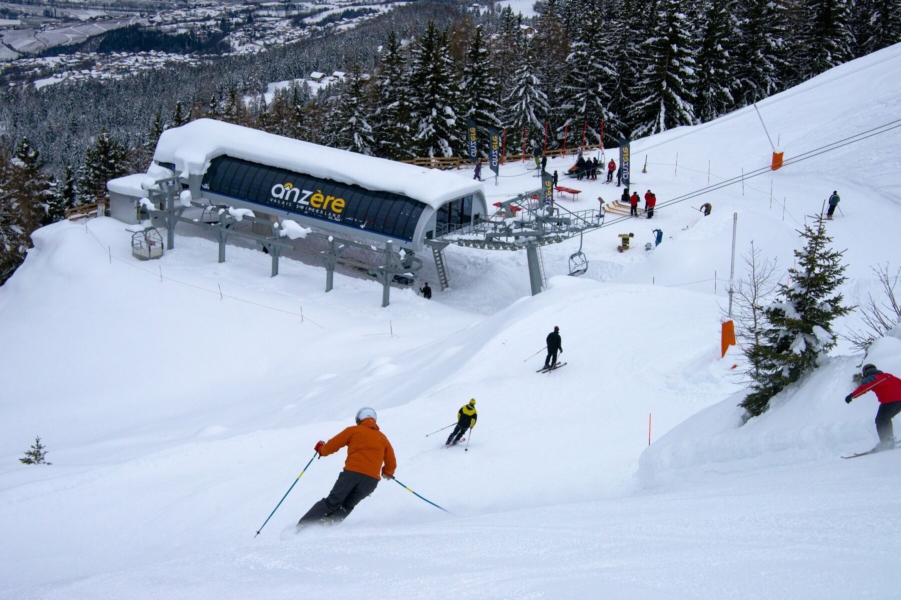 A ski resort with a chairlift, skiers, and a snow-covered landscape.