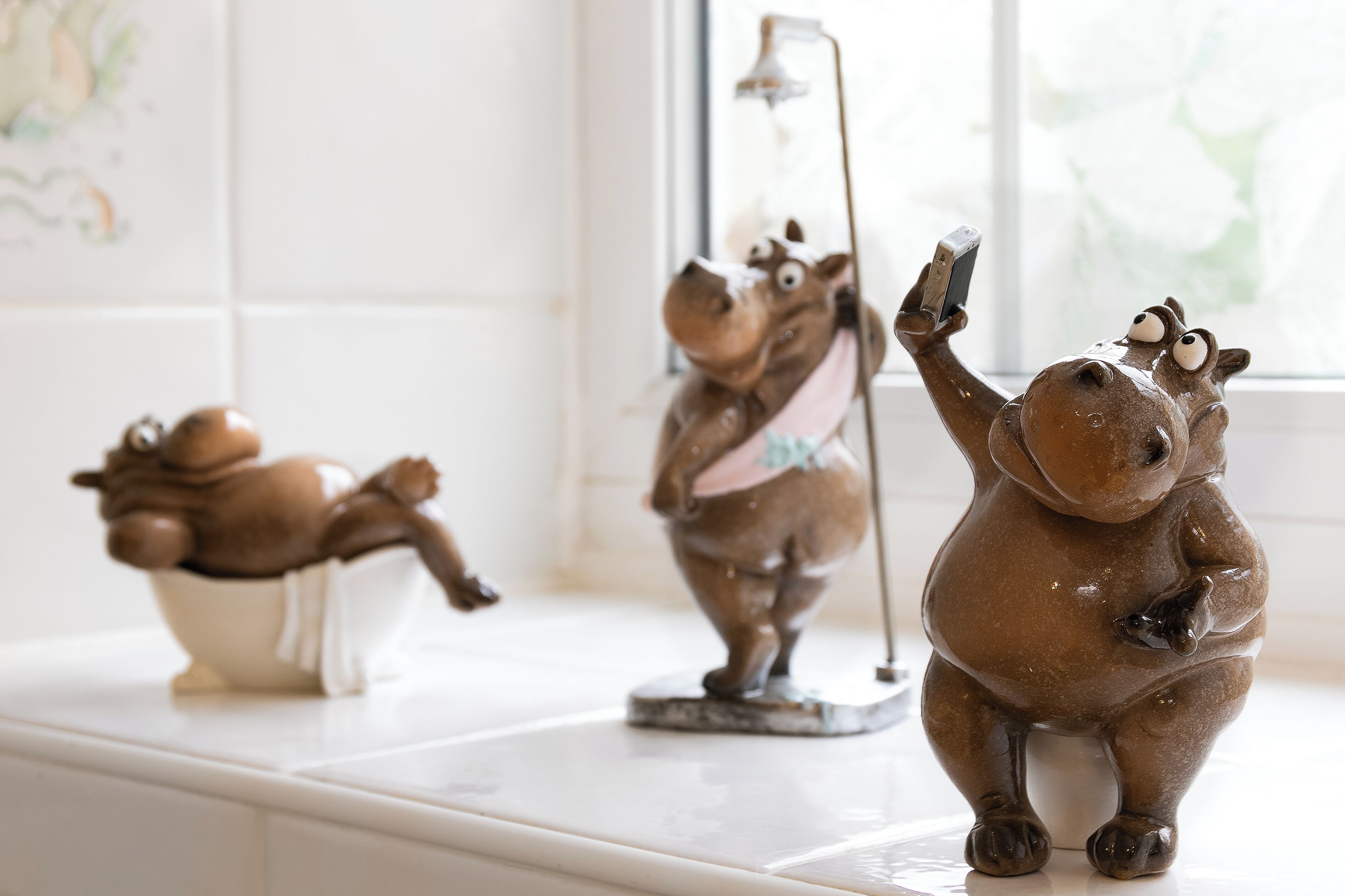Three ceramic figurines on a kitchen counter.