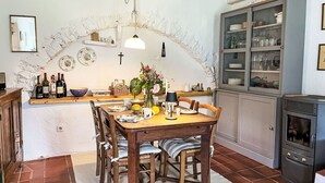 Eine rustikale Küche mit Holztisch, Stühlen und einem eingebauten Schrank.