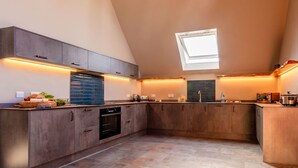 A modern kitchen with a skylight, built-in appliances, and a large island. - Beautiful private villa for 6 people with WIFI, TV and pets allowed (Newquay)