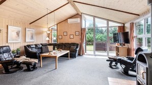 Een gezellige woonkamer met een bank, een salontafel, een open haard en een televisie.