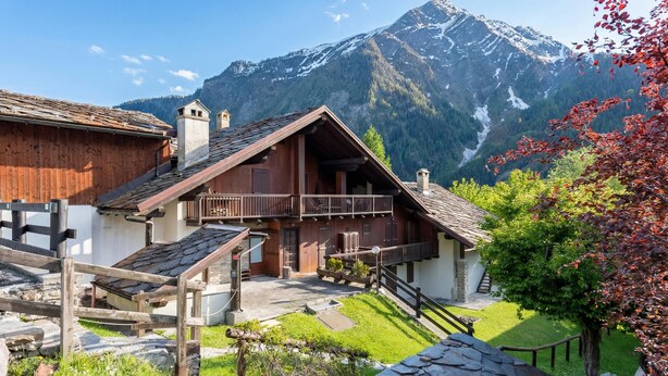 A traditional wooden chalet with a balcony, set against a backdrop of mountains. - Flats With Garden in Courmayeur (Verrand)