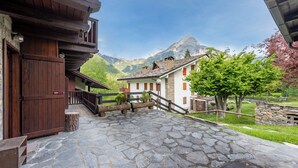 A stone staircase leading to a wooden building with a mountain view. - Flats With Garden in Courmayeur (Verrand)