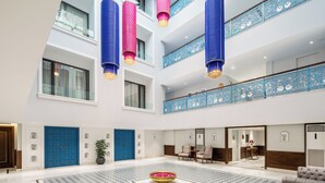 A spacious lobby with a checkered floor, a central decorative bowl, and a seating area with chairs. - MJ Sarovar Portico Haridwar (Haridwar)