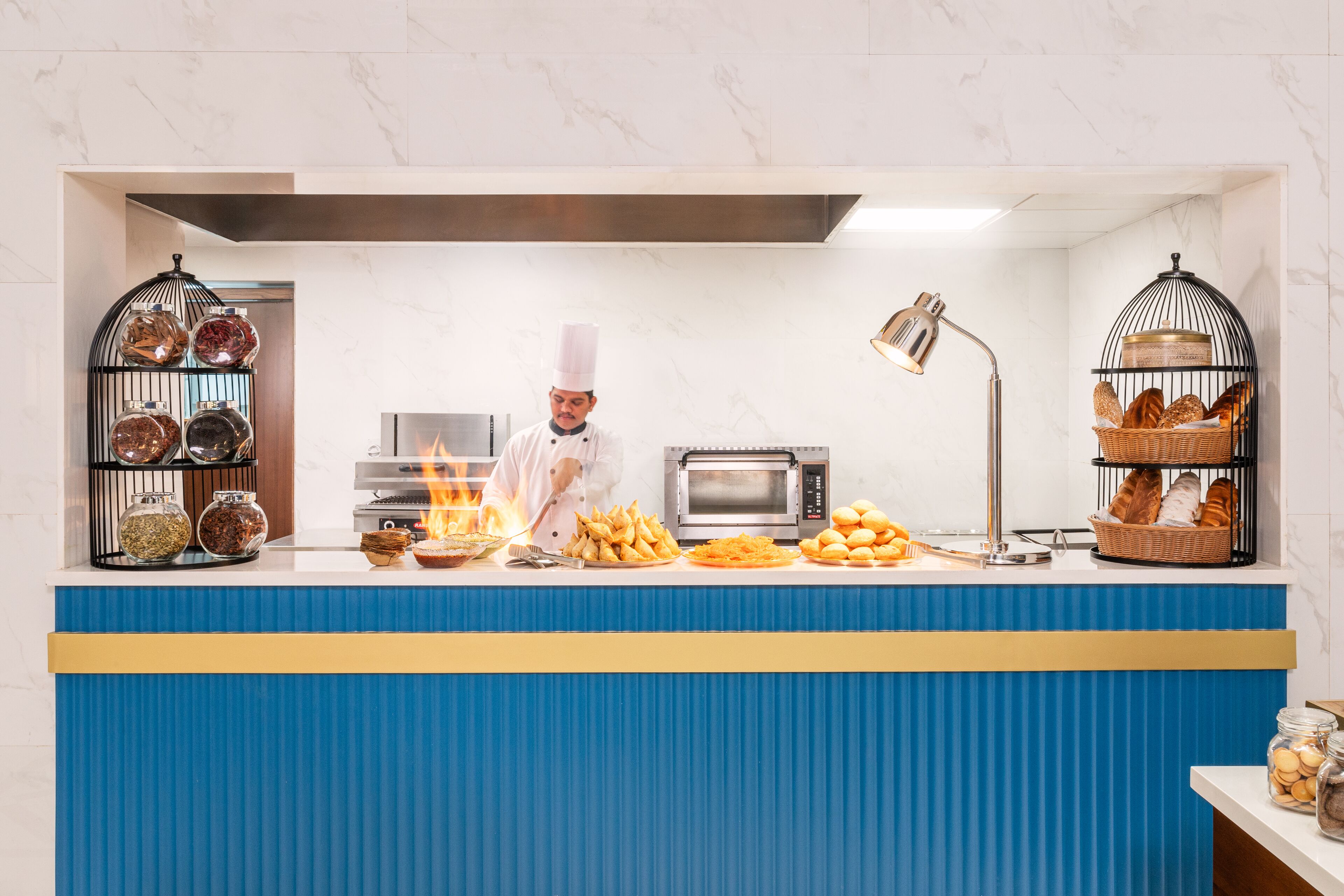A chef preparing food at a counter with a microwave and oven in the background.