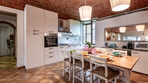 A modern kitchen with white cabinets, a tiled floor, and a brick ceiling. - Lovely apartment for 4 people with pool, WIFI, TV, patio and pets allowed (Castell'alfero)