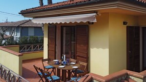 A small, yellow building with a tiled roof and a covered patio area. - Cosy apartment for 4 people with A/C, WIFI, TV and terrace (Pietrasanta)