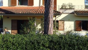 A two-story house with a tiled roof, wooden shutters, and a visible balcony. - Cosy apartment for 4 people with A/C, WIFI, TV and terrace (Pietrasanta)