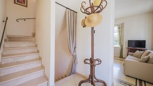 A staircase leading to a landing, a floor lamp with a woven shade, a sofa, and a television in a living room. - Nice apartment for 3 guests with WIFI, TV and terrace (Camaiore)