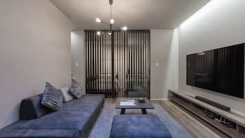 Relax in this stylish living room with a sofa, ottoman, and flat-screen TV.