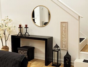 A bedroom with a bed, a desk, a mirror, a welcome sign, and a staircase. - Milton/Alpharetta 5BR Home 5-bds/up to 12 guests - House & Event Venue (Alpharetta)