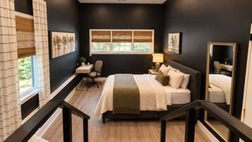 Une chambre à coucher comprenant un lit, un bureau, une chaise, une fenêtre avec des stores et un miroir.