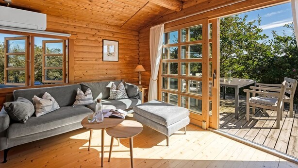 En mysig stuga med en soffa, ett litet bord och en bänk.
