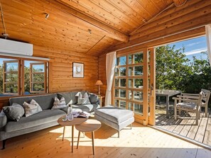 A cozy cabin interior with a sofa, a small table, and a bench. - "Christl" - 500m from the sea by Interhome (Henne)