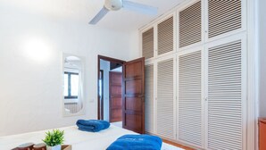 A bedroom with a bed, a wooden wardrobe, a ceiling fan, and a window with curtains. - Cosy apartment in villa for 8 people with WIFI, A/C, TV and patio (Pula)