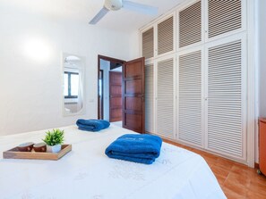 A bedroom with a bed, a wooden wardrobe, a ceiling fan, and a window with curtains. - Nice apartment in villa for 8 guests with A/C, WIFI, TV and patio (Pula)