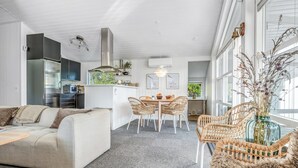 A modern interior with a living area, kitchen, and dining space.