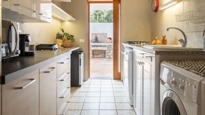 Una cucina compatta con forno a incasso, lavello e lavatrice.