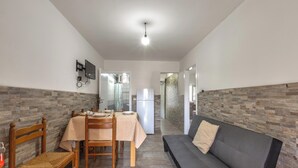 A compact living space with a dining area, a sofa, and a kitchenette. - 4145 Giusy House by Barbarhouse (Lecce)