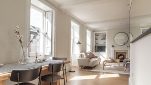 Una sala de estar moderna con chimenea, un comedor con mesa y sillas, y un sofá.