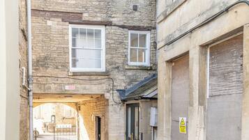 Stroll through a charming, cobblestone-lined alleyway leading to a secure gated entrance.