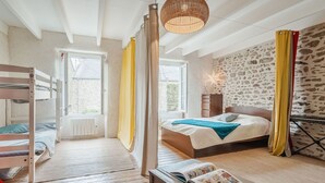 A room with a bunk bed, a bedside table with a book, a hanging light fixture, and a window with curtains. - Wonderful  villa for 5 people with WIFI and pets allowed (La Richardais)