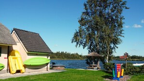 Et hus med swimmingpool, trampolin og båd.