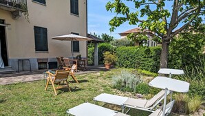 Une terrasse avec des meubles d’extérieur, une table et une plante en pot.