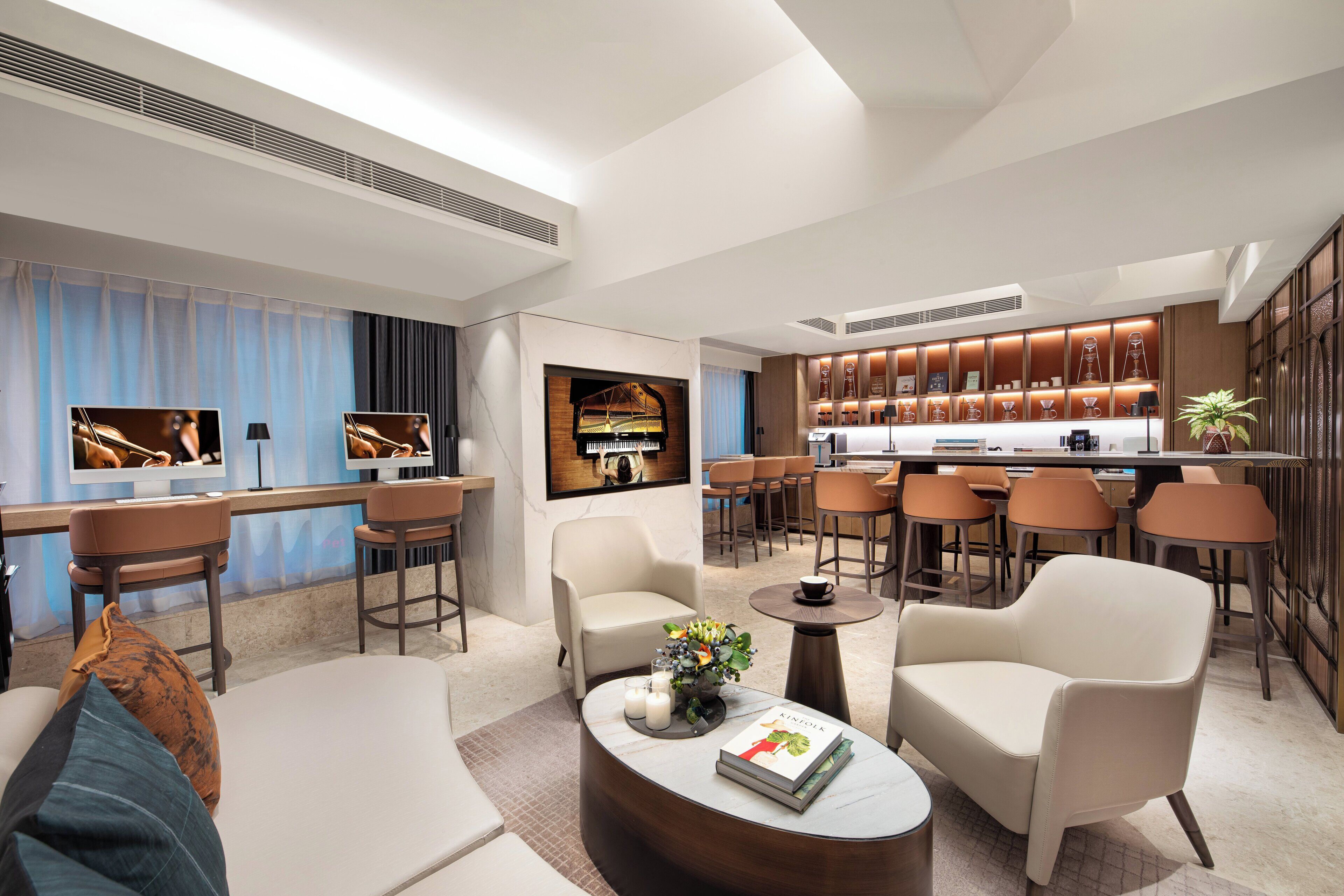 Un salon moderne avec un piano, des sièges confortables et un coin bar.