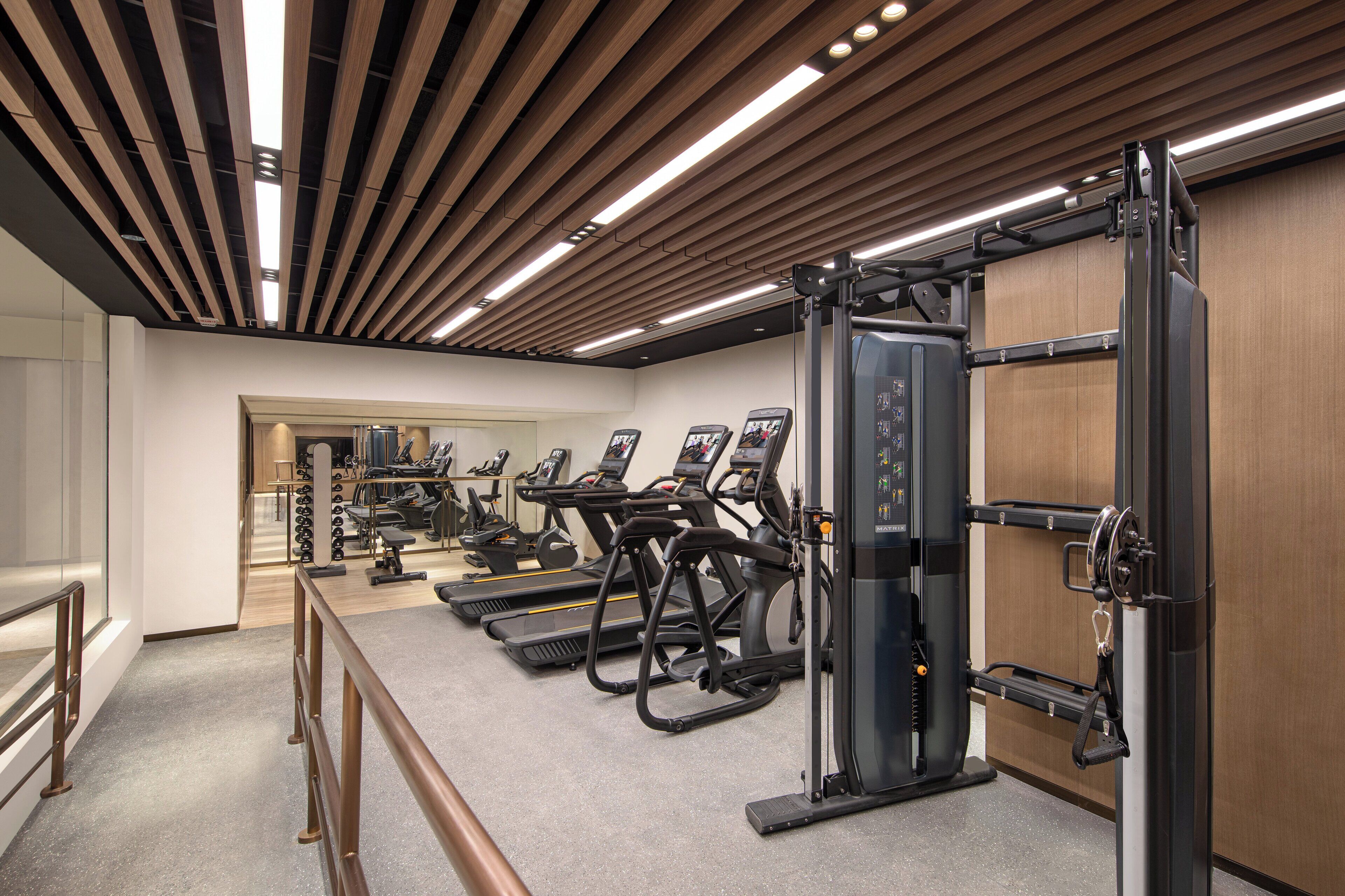 A gym with treadmills, elliptical machines, and weightlifting equipment.