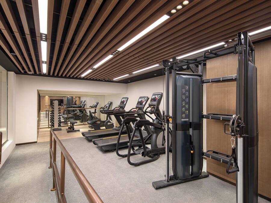 A gym with treadmills, elliptical machines, and weightlifting equipment.
