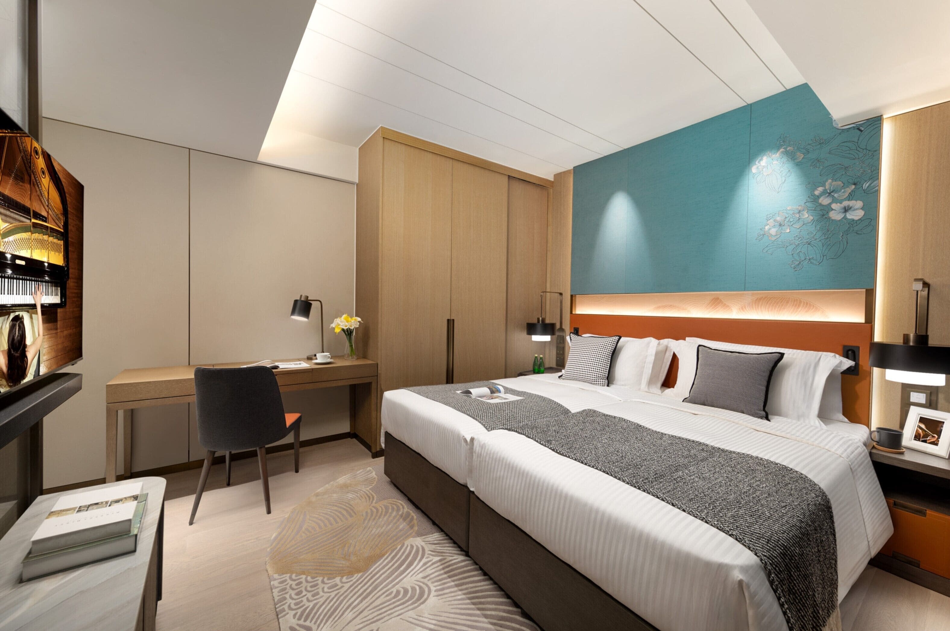 A modern hotel room with a large bed, a desk, and a seating area.