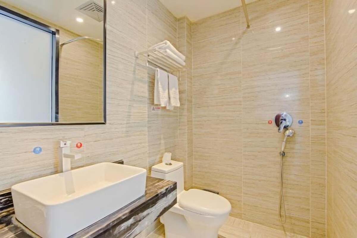 Une salle de bain moderne avec une grande baignoire, des toilettes et une douche.