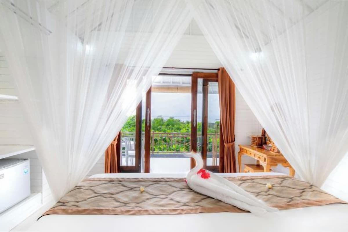 Un dormitorio con cama, mesita de noche y vistas al exterior.