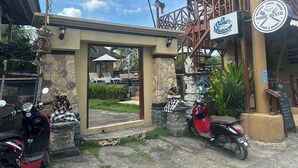 Un restaurante con mesas al aire libre, un letrero que dice 'Blue Lagoon' y un cartel que indica 'Made Resto' con servicios de comida y bebidas.