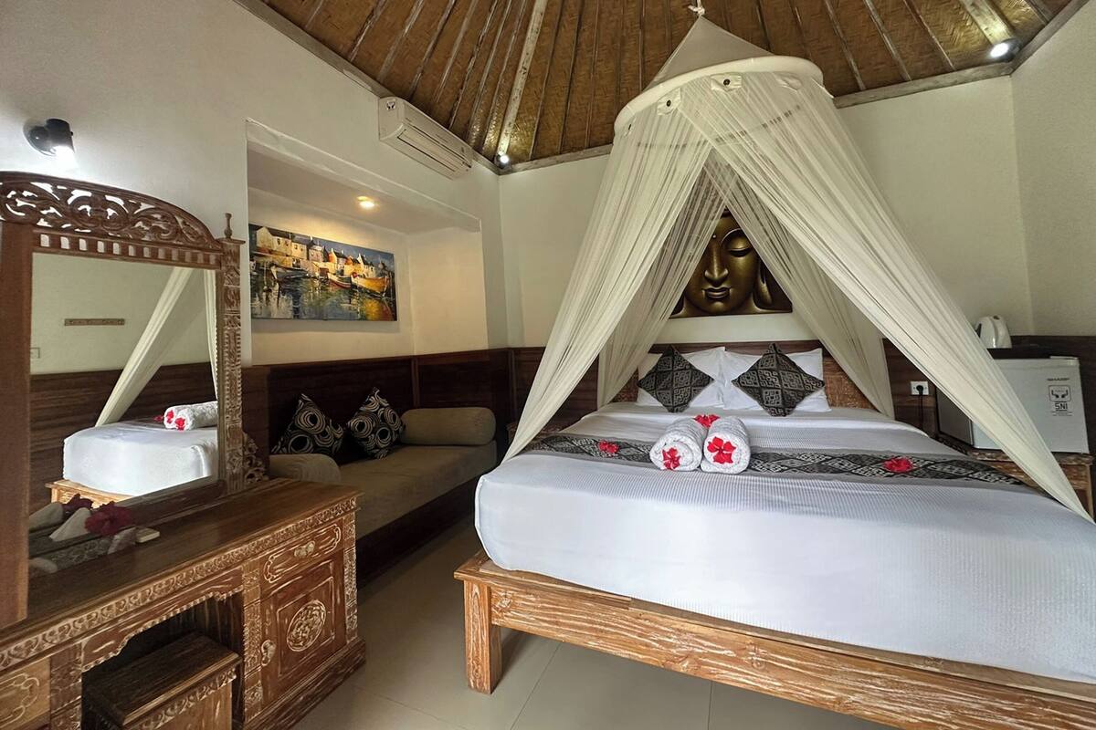 Une chambre à coucher avec un lit à baldaquin, une commode en bois, un canapé et un tableau accroché au mur.
