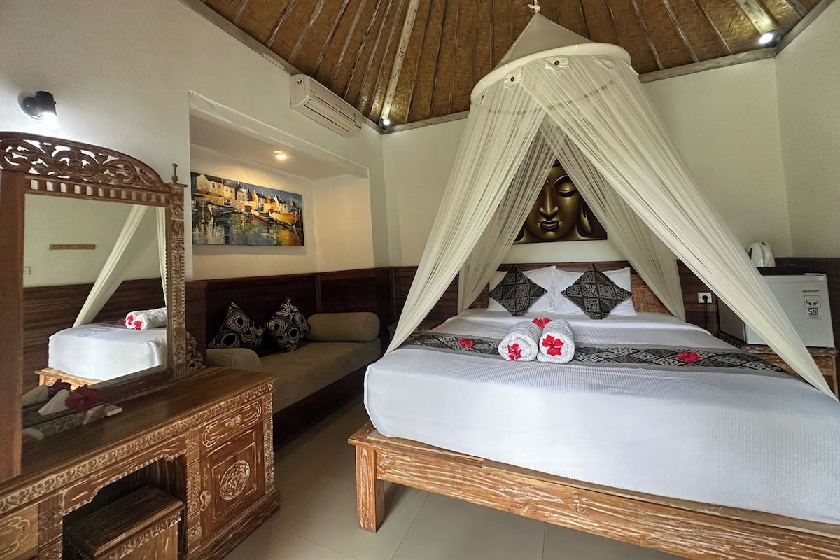 A bedroom with a canopy bed, a wooden dresser, a sofa, and a painting on the wall.